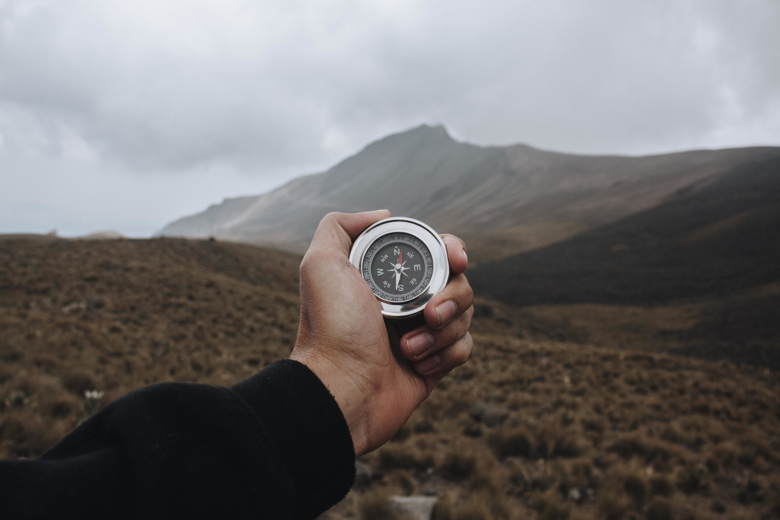 Closeup shot of a person holding a compass A closeup shot of a person holding a compass